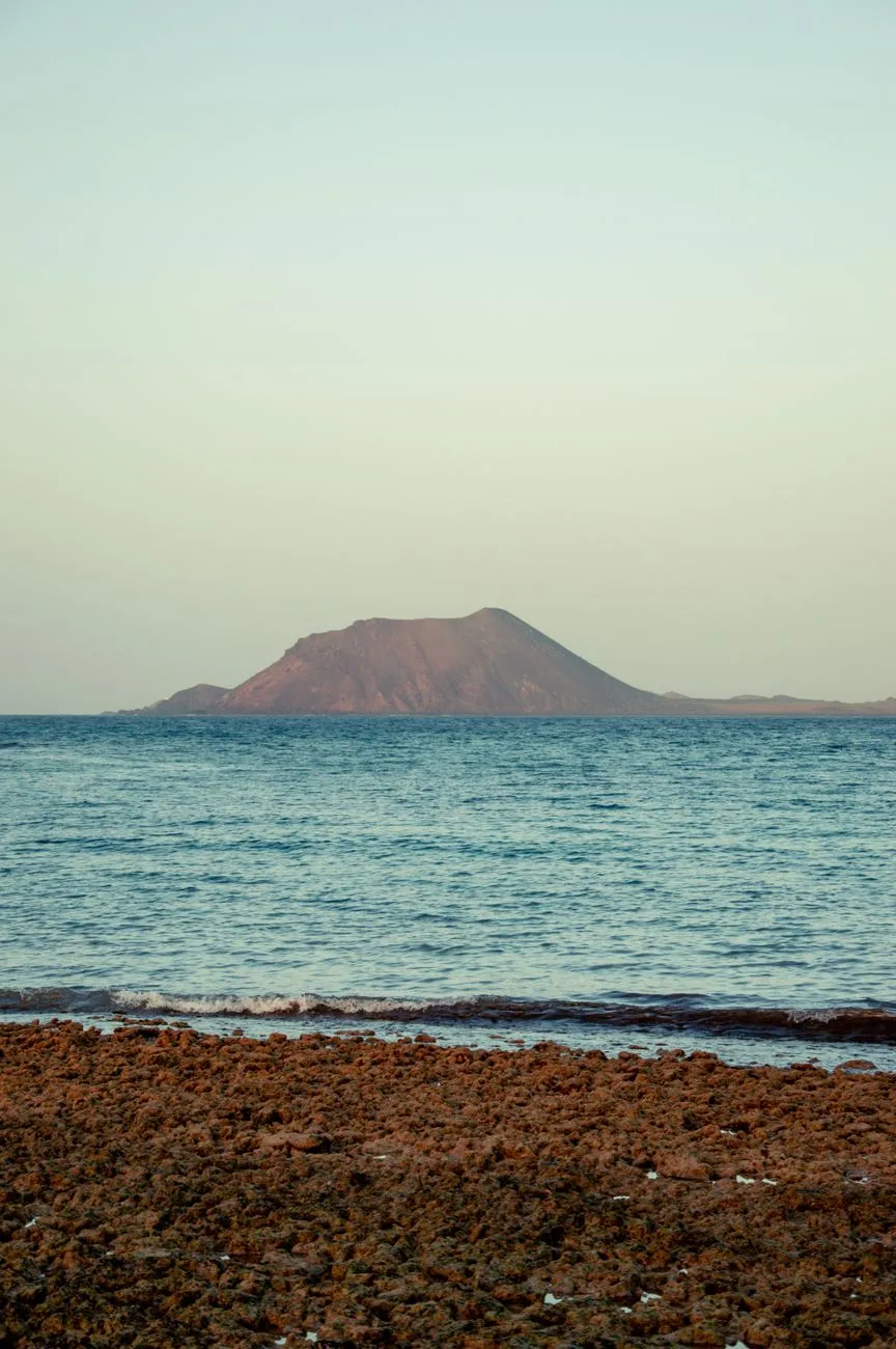 Isla de Lobos across the strait from Corralejo's lava shore